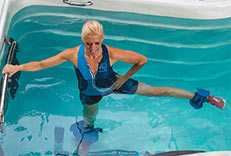 A woman exercising in a Michael Phelps Swim Spa by Master Spas